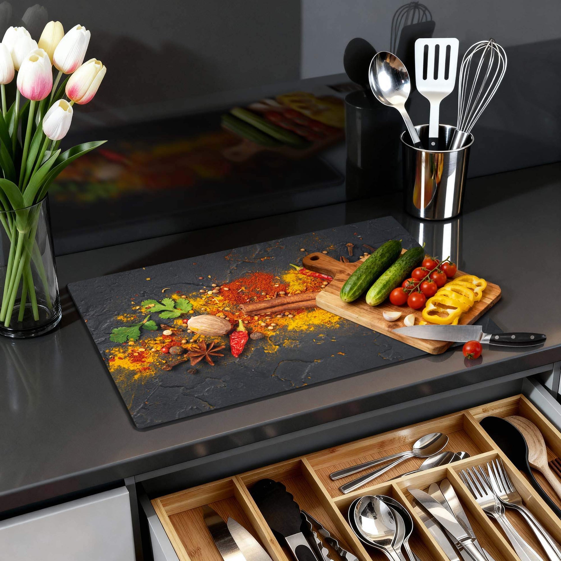 Spice Canvas – Inductie Beschermer met kleurrijk kruidenmotief op antraciete achtergrond in moderne keuken.