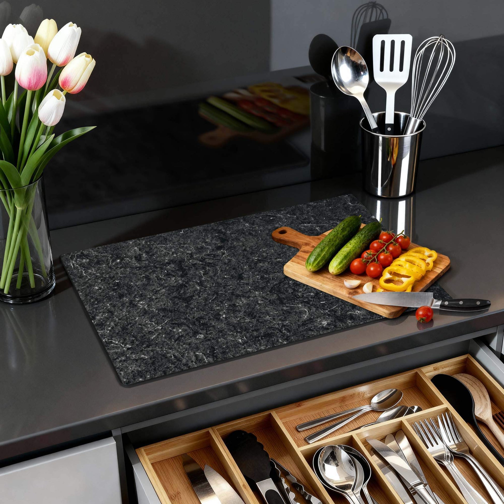 Nero Marble - Inductie Beschermer op een keukenblad met groenten en keukengerei.