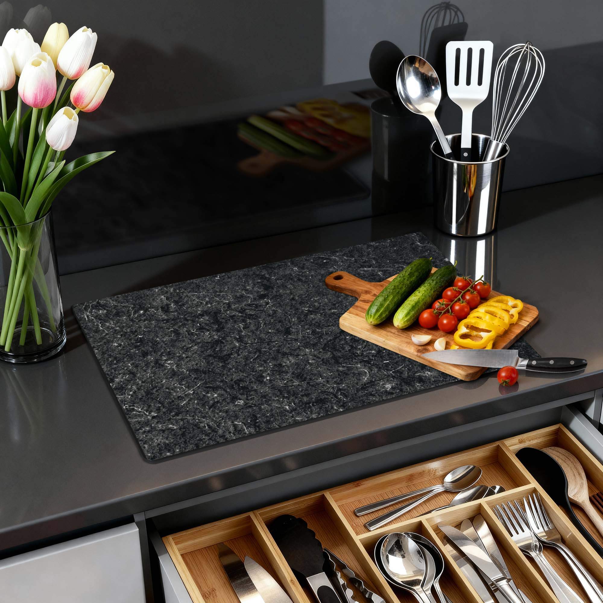 Nero Marble - Inductie Beschermer op een keukenblad met groenten en keukengerei.