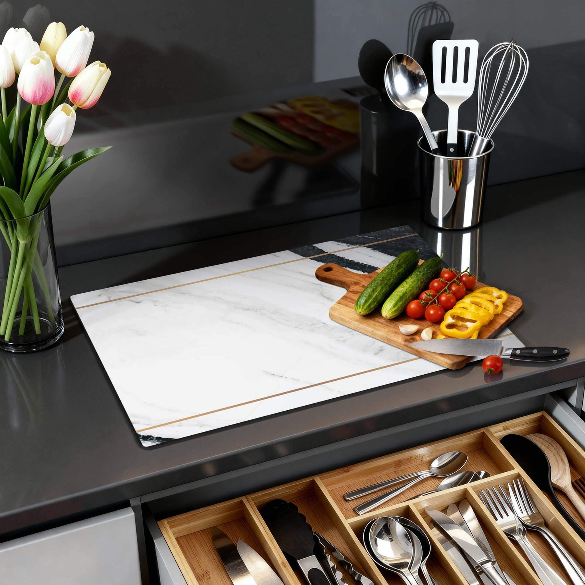 Marble Modern - Inductie Beschermer op een moderne keukenwerkblad met groenten en bloemen.