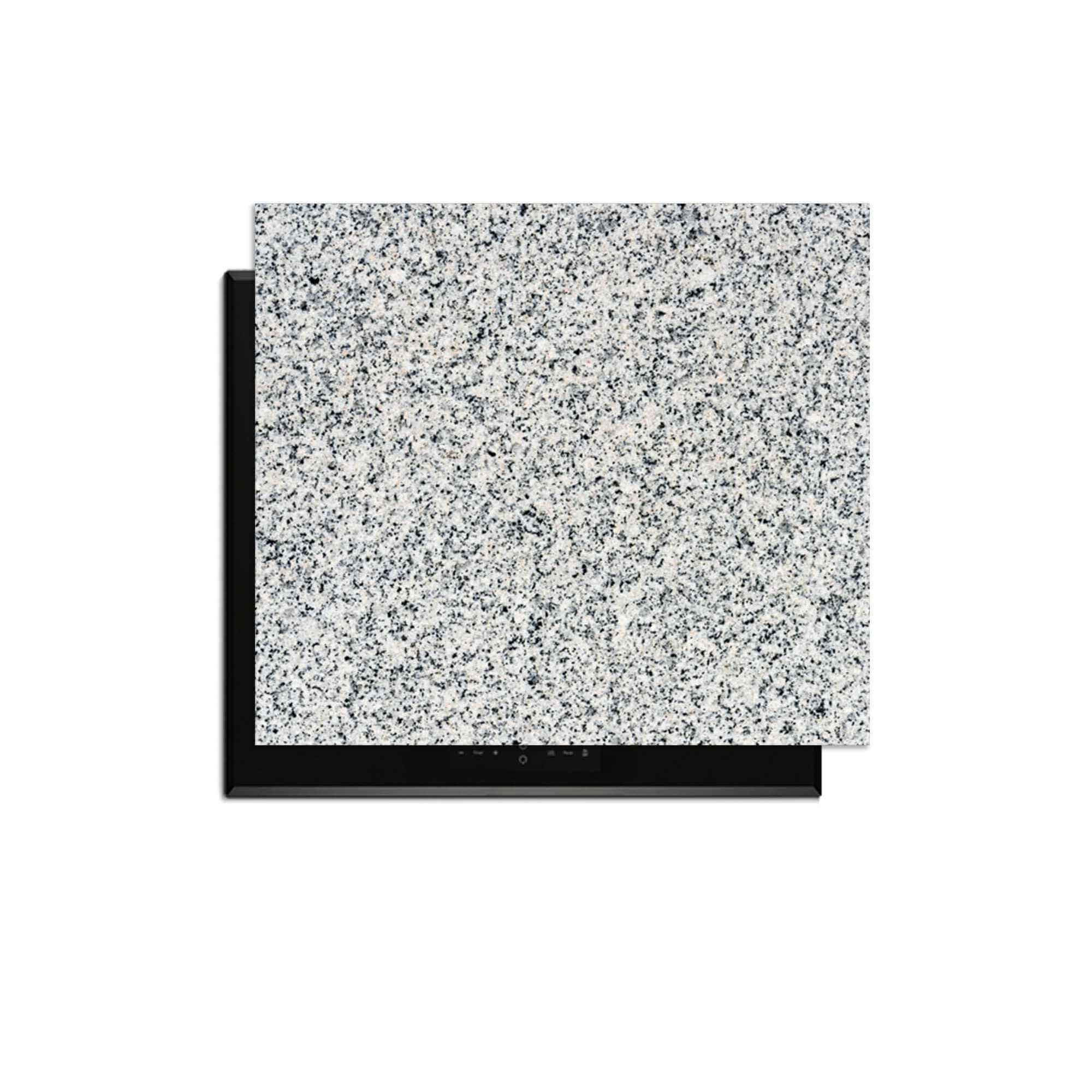 Nordic Mist - Inductie Beschermer met grijs graniet patroon bovenop een zwarte inductiekookplaat.