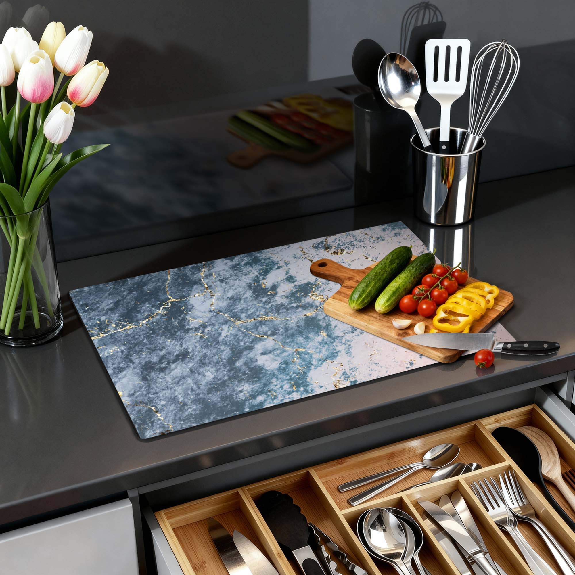 Eleganter Ozeanmarmor - Induktionsschutz auf einer Küchenoberfläche mit Gemüse und Blumen.