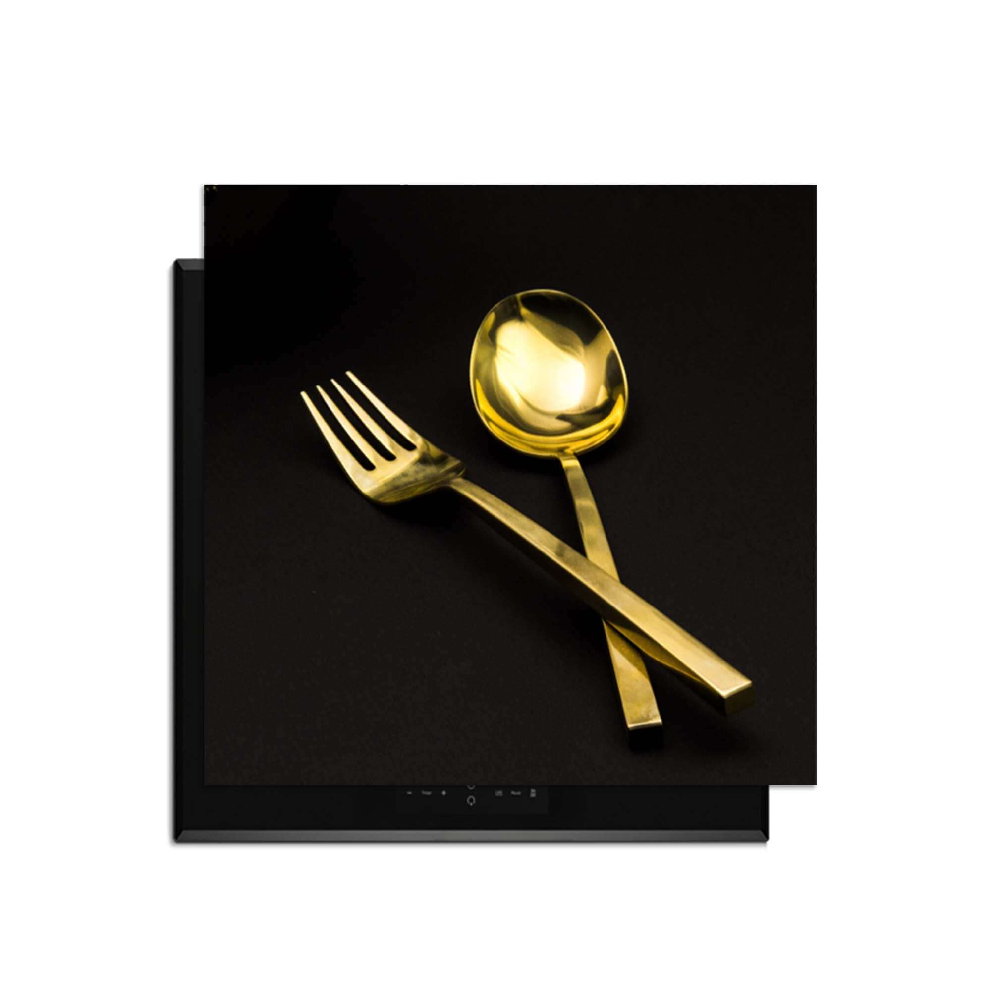 Dining Deluxe - Inductie Beschermer met luxe gouden bestek op een zwarte achtergrond.