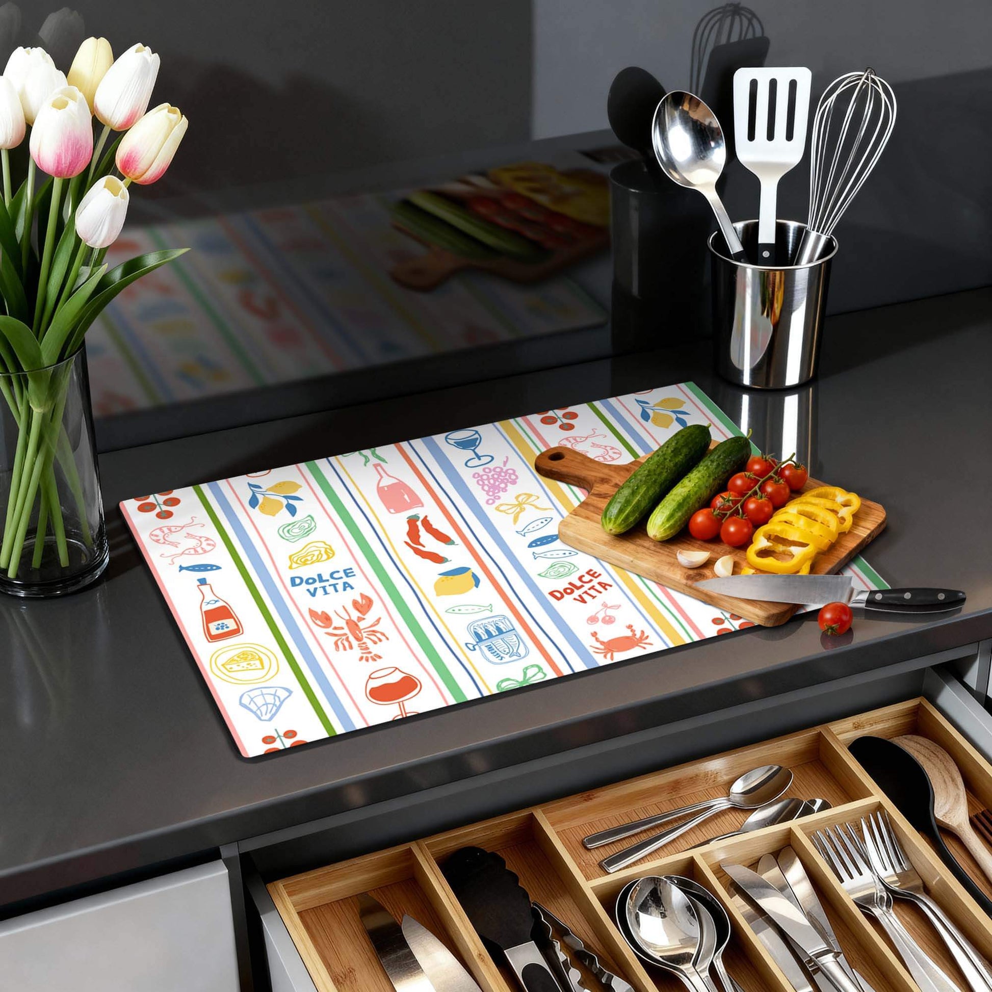 Dolce Stripes - Inductie Beschermer met kleurrijke strepen en mediterrane iconen op een keukenblad.