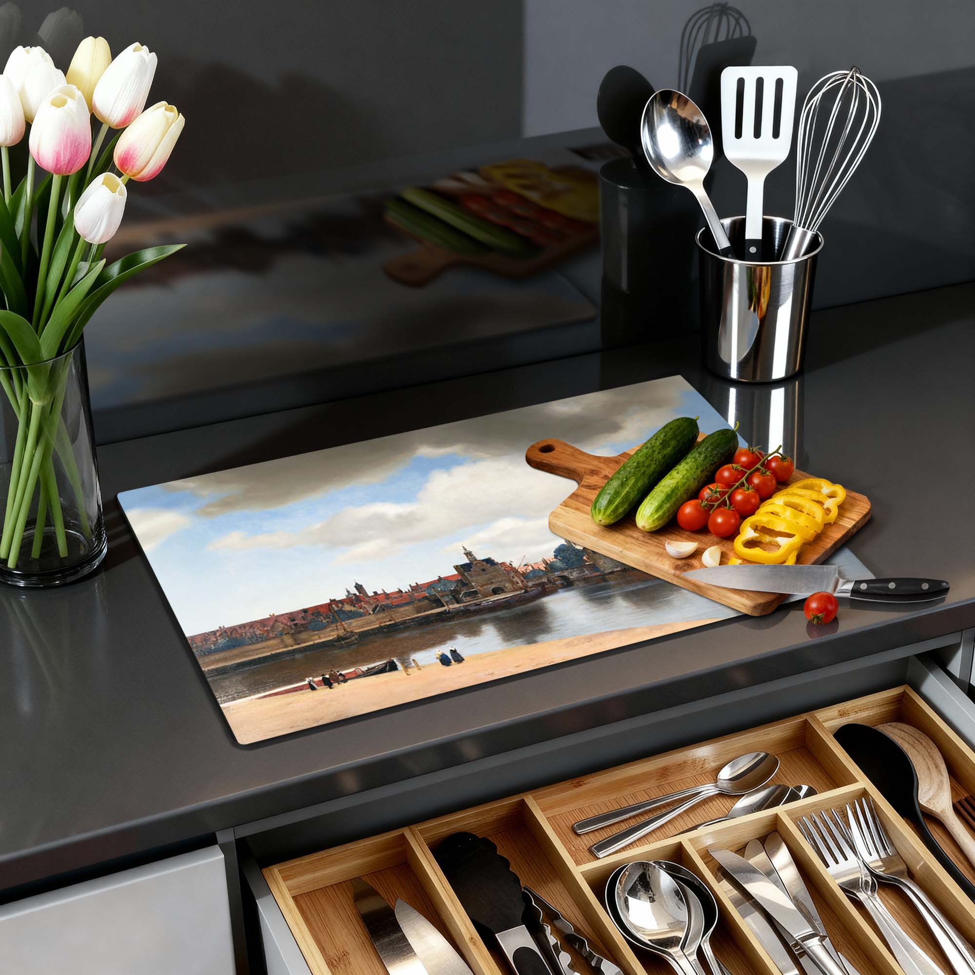 Gezicht op Delft – Inductie Beschermer in moderne keuken, met tulpen en keukenbenodigdheden op het aanrecht.