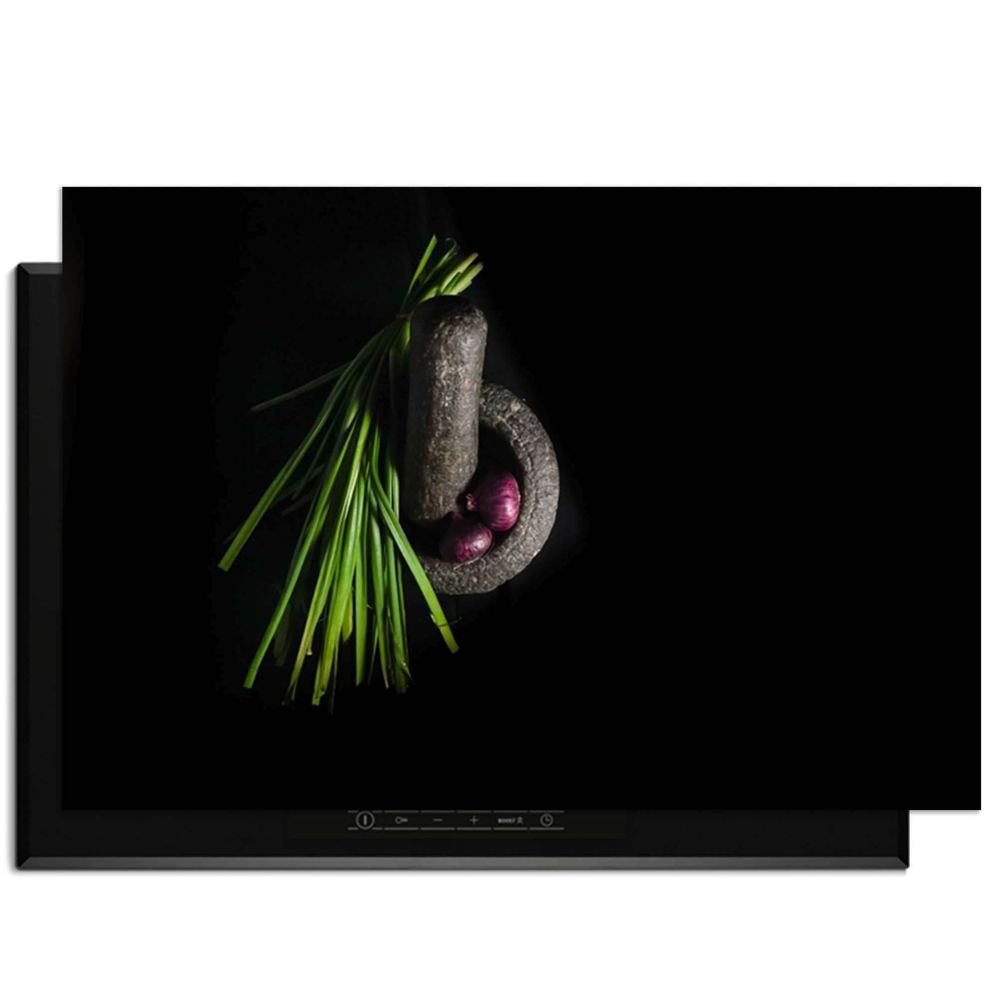 Midnight Herb - Inductie Beschermer met chives en een vijzel op een zwarte achtergrond.