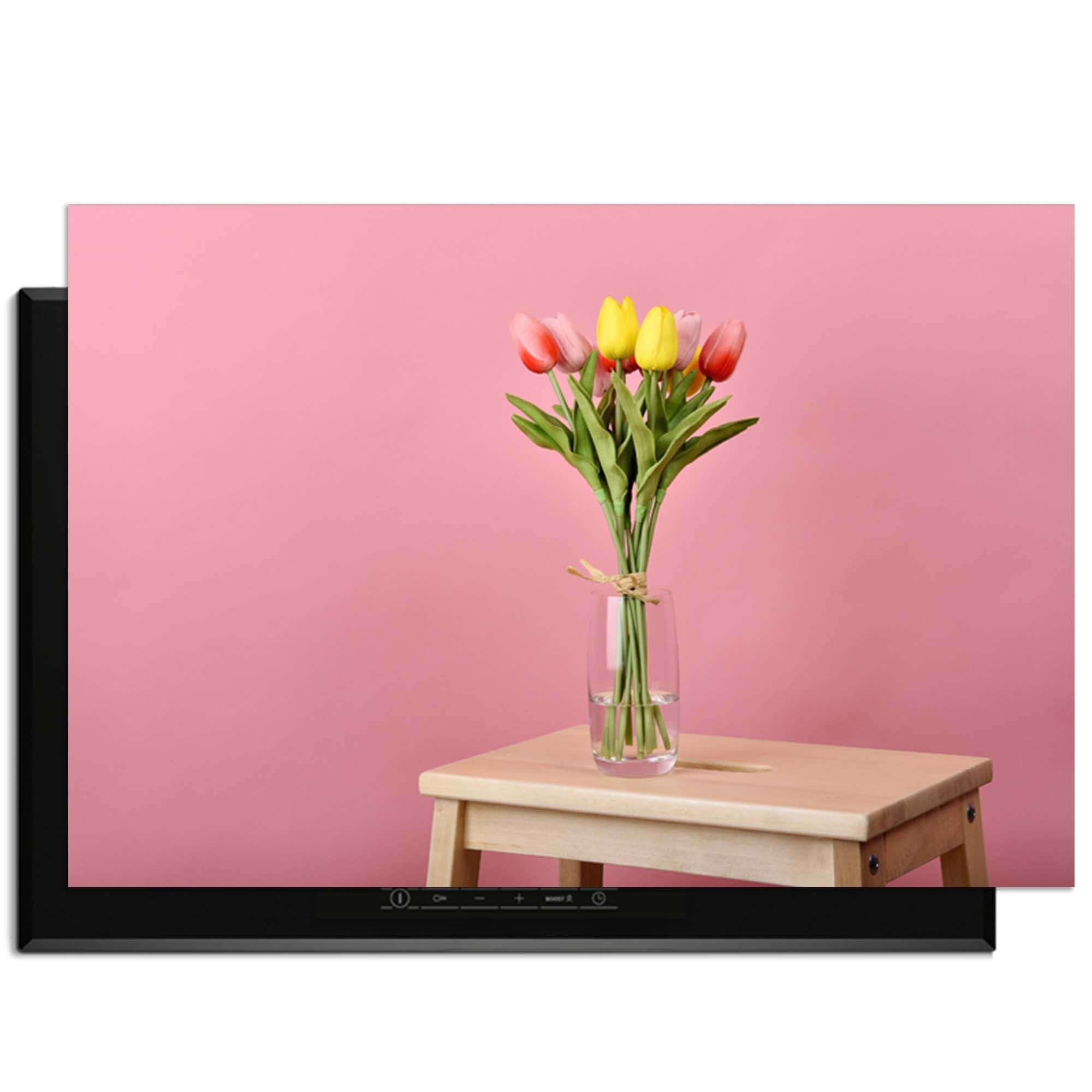 Pastel Spring - Inductie Beschermer met een vaas bloemen op een houten tafel met roze achtergrond.