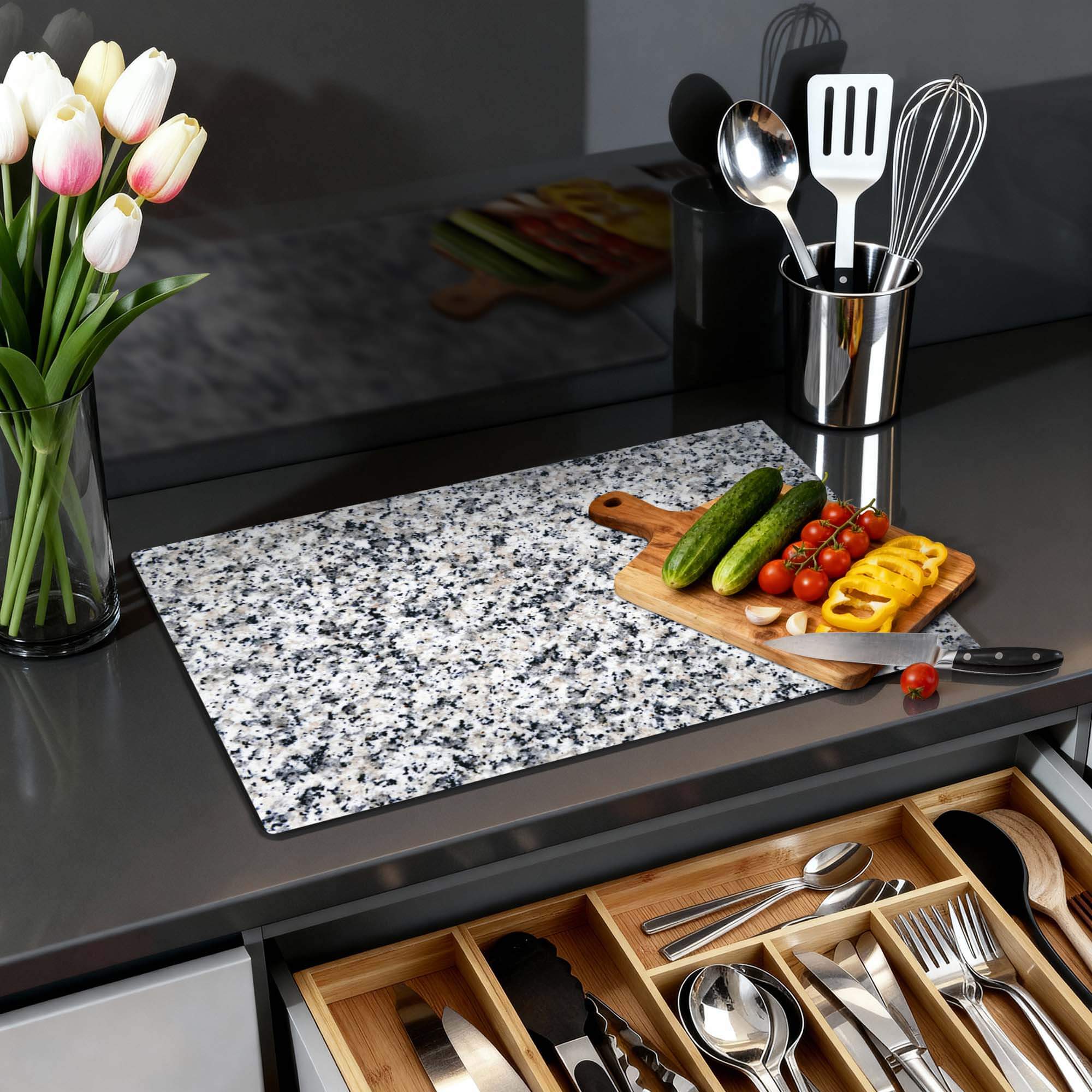 Classic Granite - Induction Protector auf einer Küchenarbeitsplatte mit Gemüse und Utensilien.