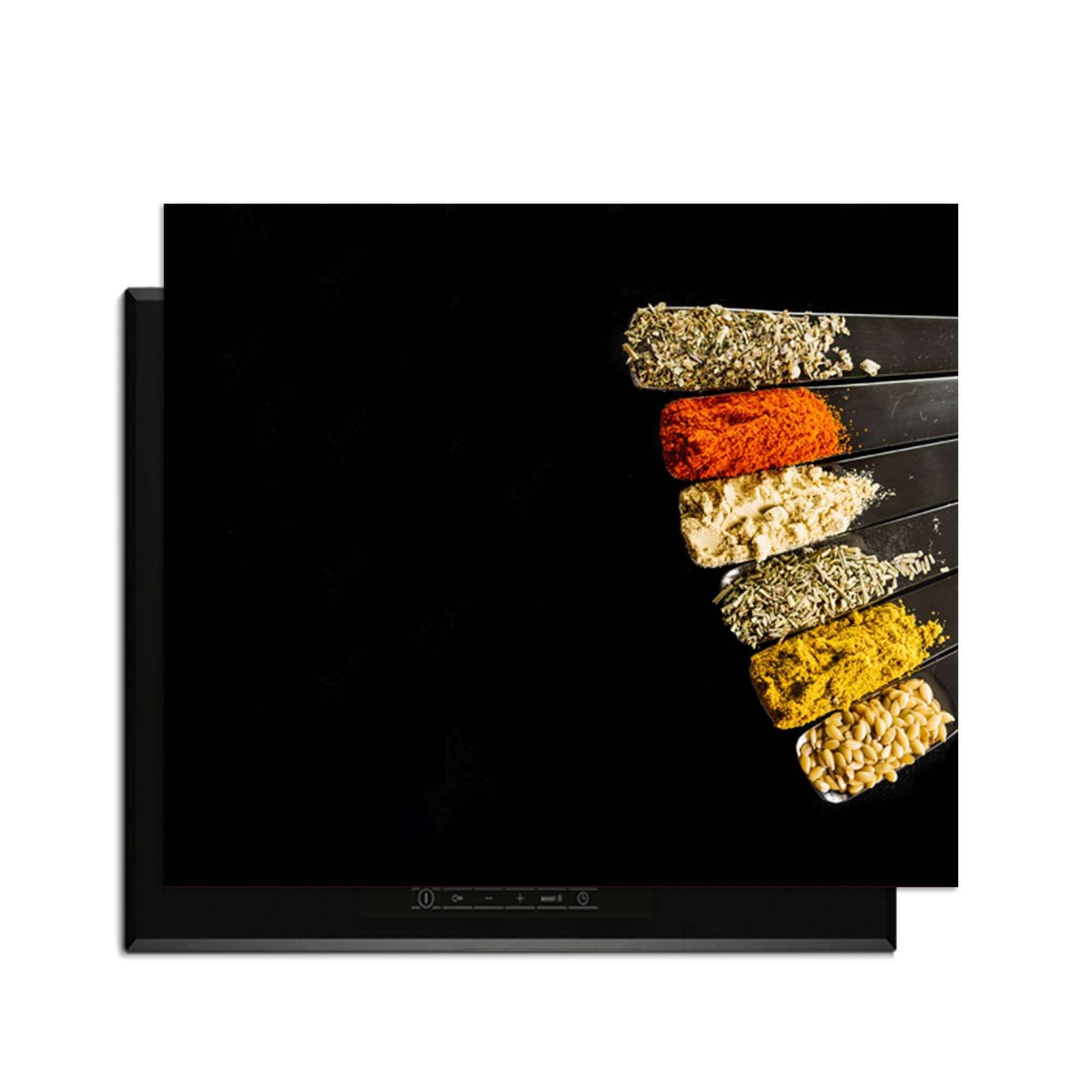 Spice Fan - Inductie Beschermer met verschillende specerijen op een zwarte achtergrond.