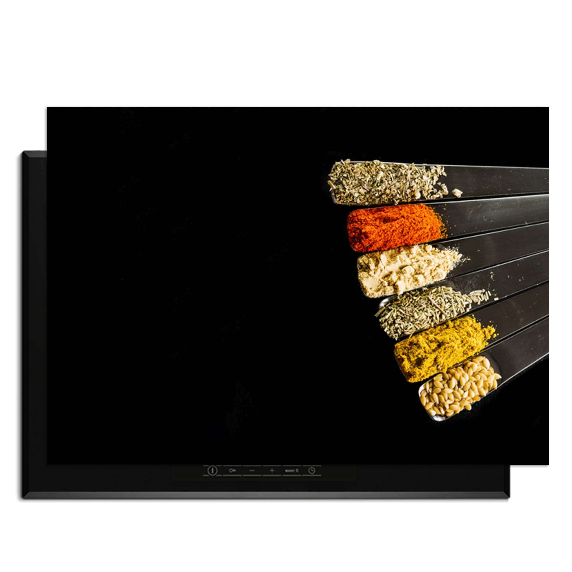 Spice Fan - Inductie Beschermer met verschillende specerijen op een zwarte achtergrond.