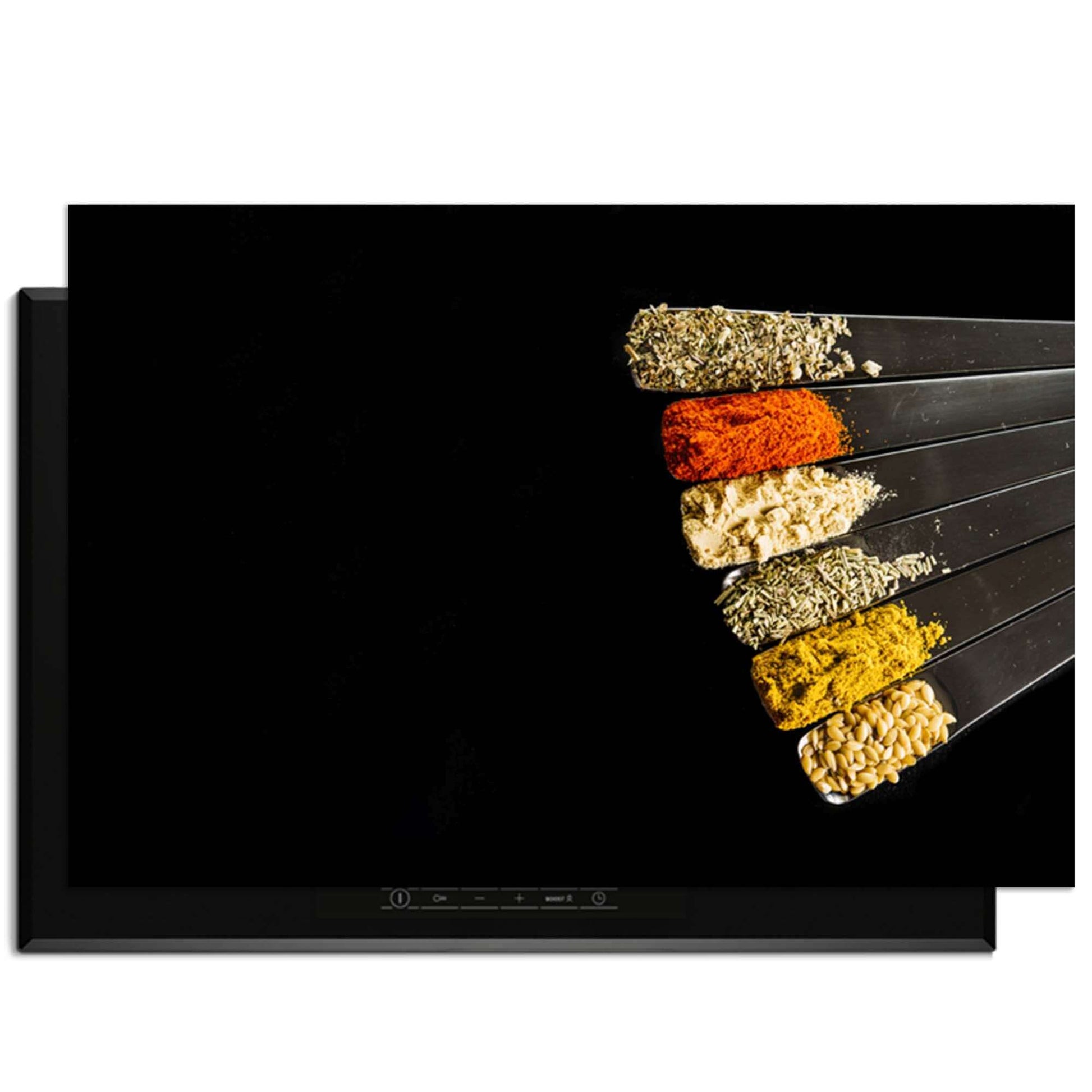 Spice Fan - Inductie Beschermer met diverse specerijen in maatlepels op een zwarte achtergrond.