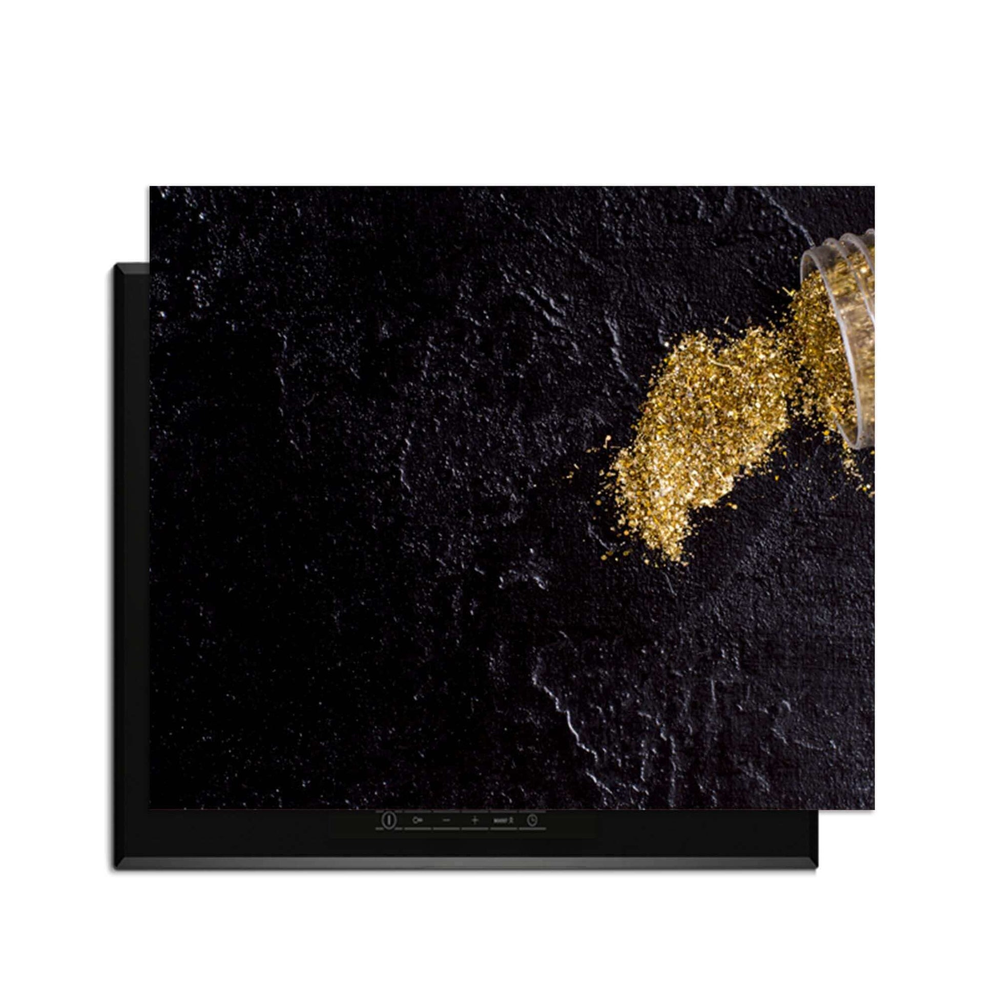 Spilled Gold - Inductie Beschermer op een moderne inductiekookplaat met gouden glitters.