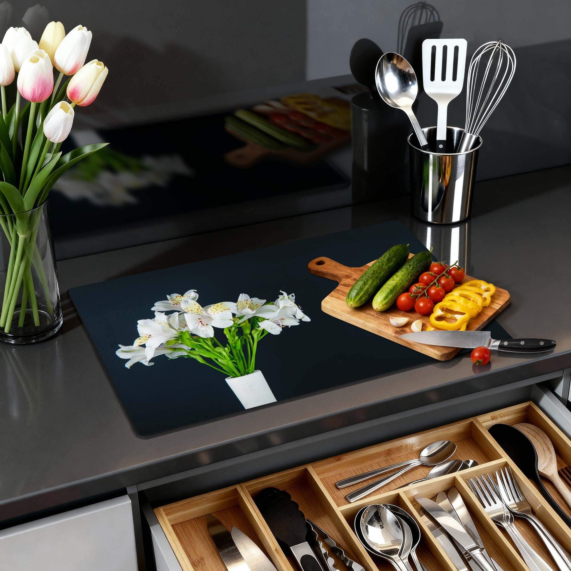 White Whisper - Inductie Beschermer op een moderne keuken ondergrond met bloemen en snijplank.