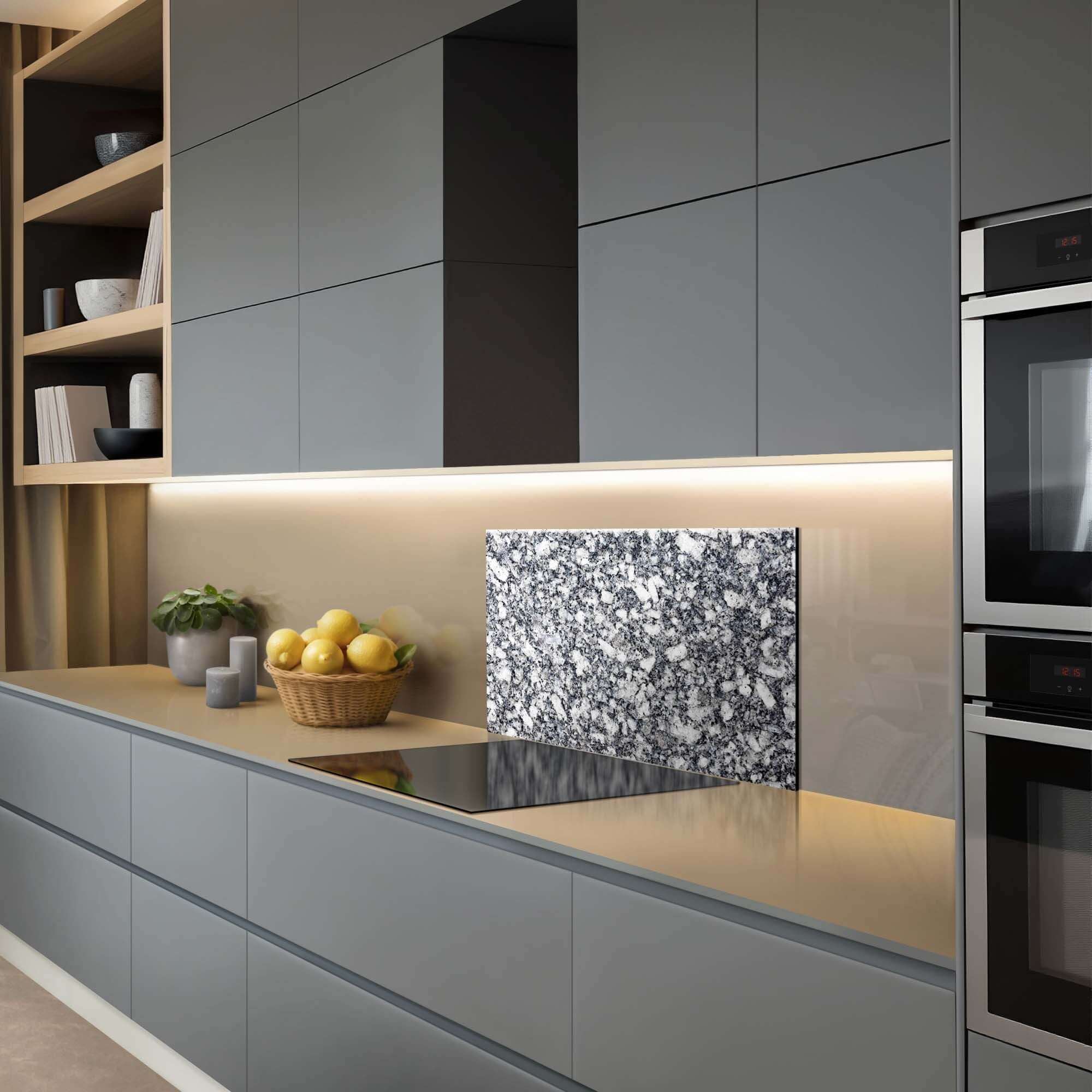 Luxe keuken met Midnight Granite Spatscherm, een stijlvol blauwgrijs granieten spatscherm op een moderne aanrecht met keukenaccessoires. Spatwand.