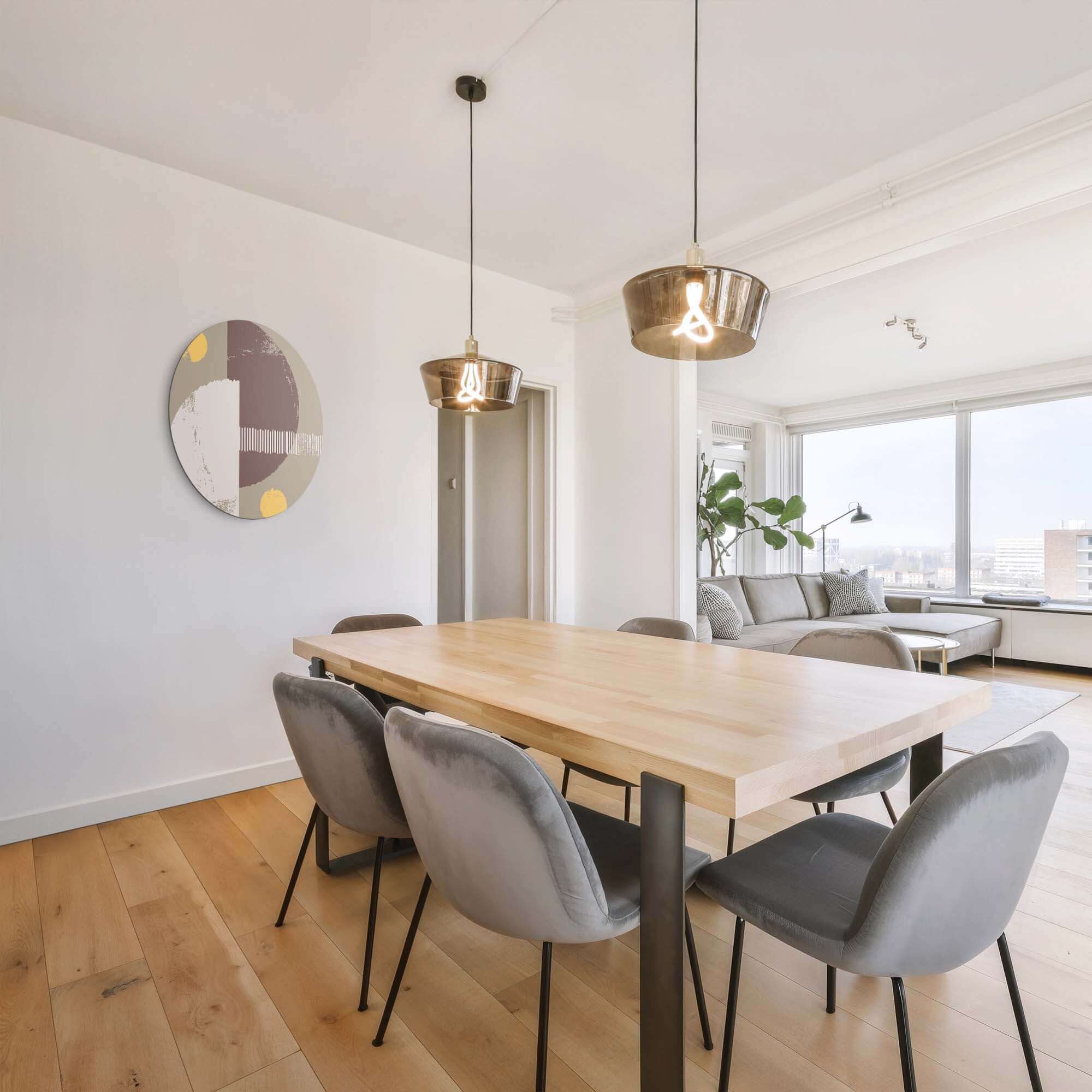 Lunar Balance - Muurcirkel in moderne eetkamer met houten tafel en grijze stoelen, versterkt door subtiele aardetinten en abstract design.