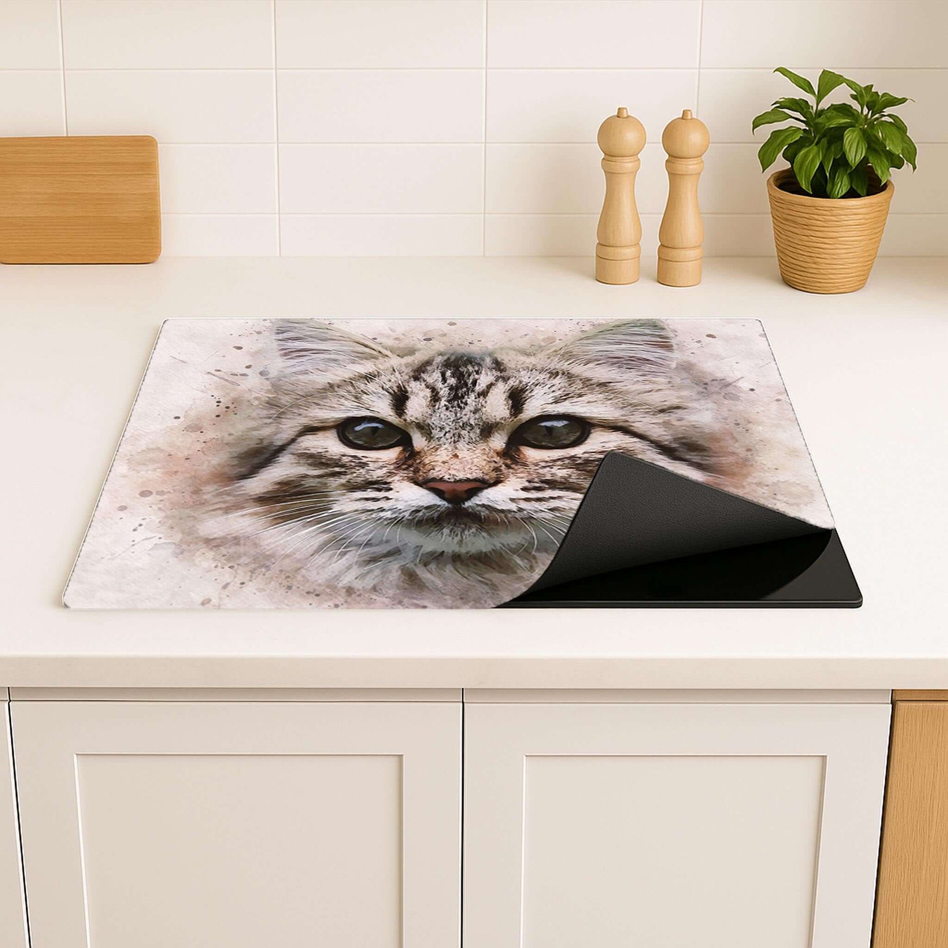 Inductiebeschermer met kattenillustratie, geplaatst op een licht aanrecht