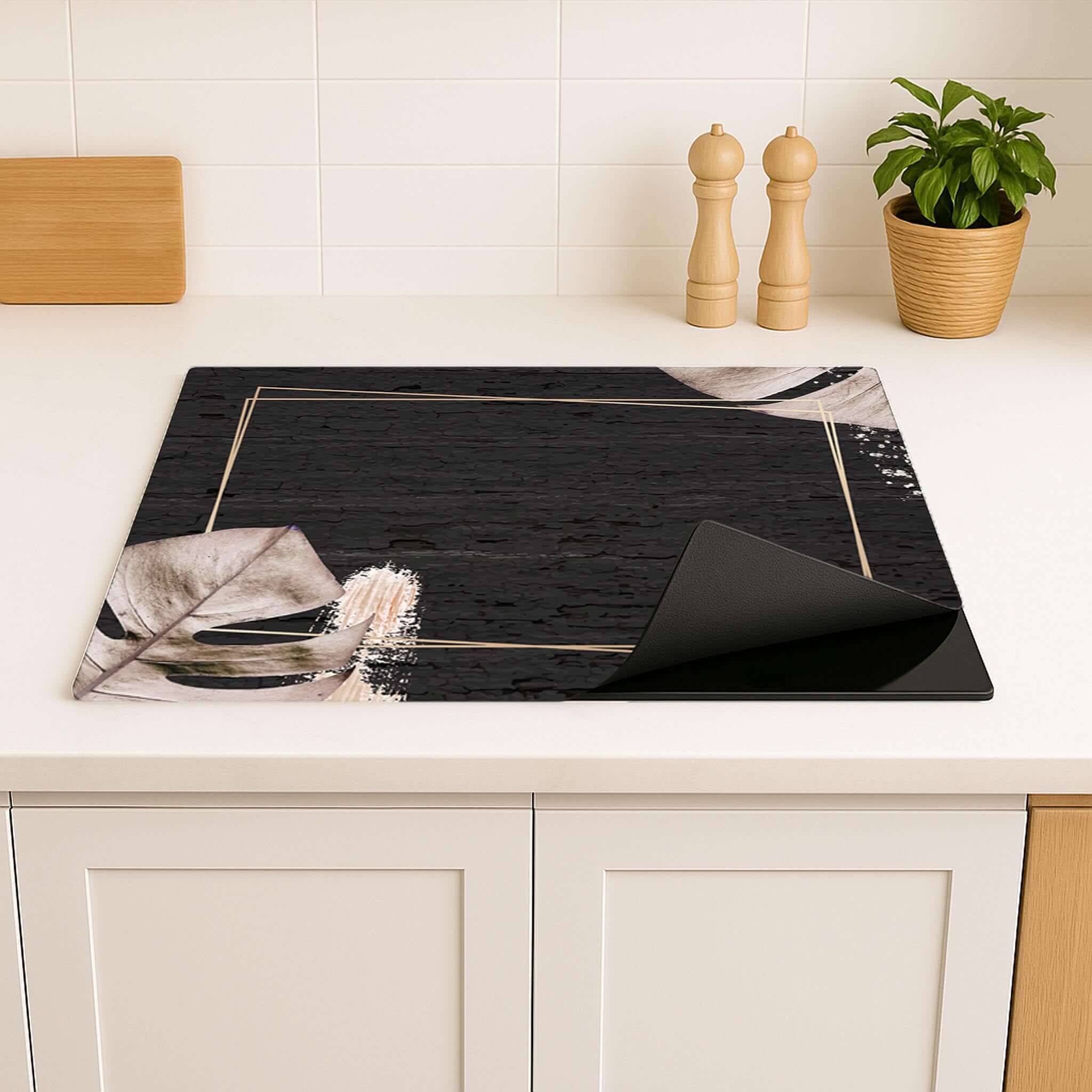 Sfeervolle inductie beschermer met botanisch design in een lichte keuken