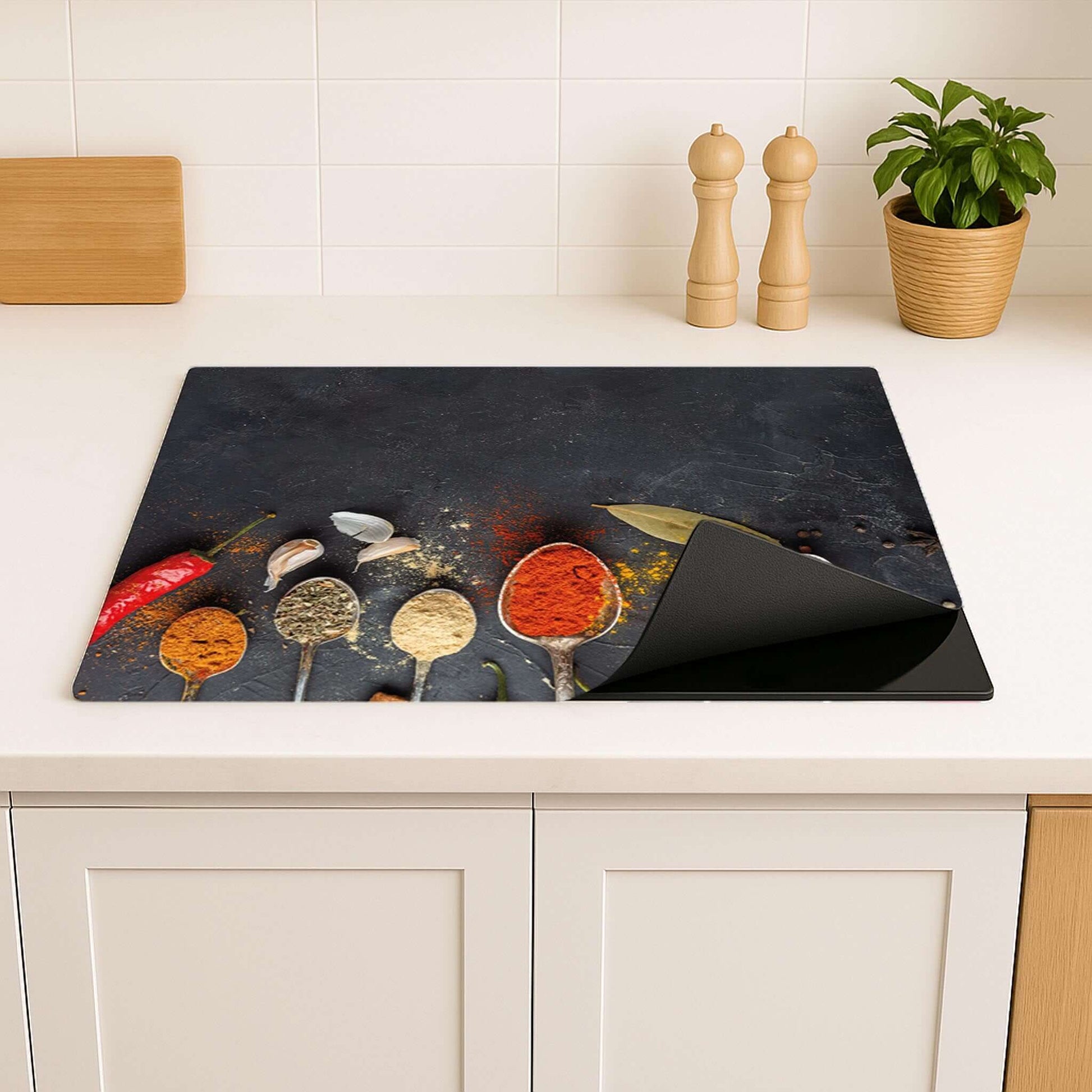 Inductiebeschermer met specerijenmotief op een houten keukenblad.
