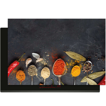 Overzicht van de Spice Essence inductiebeschermer met kleurrijke specerijen op een donkere achtergrond.