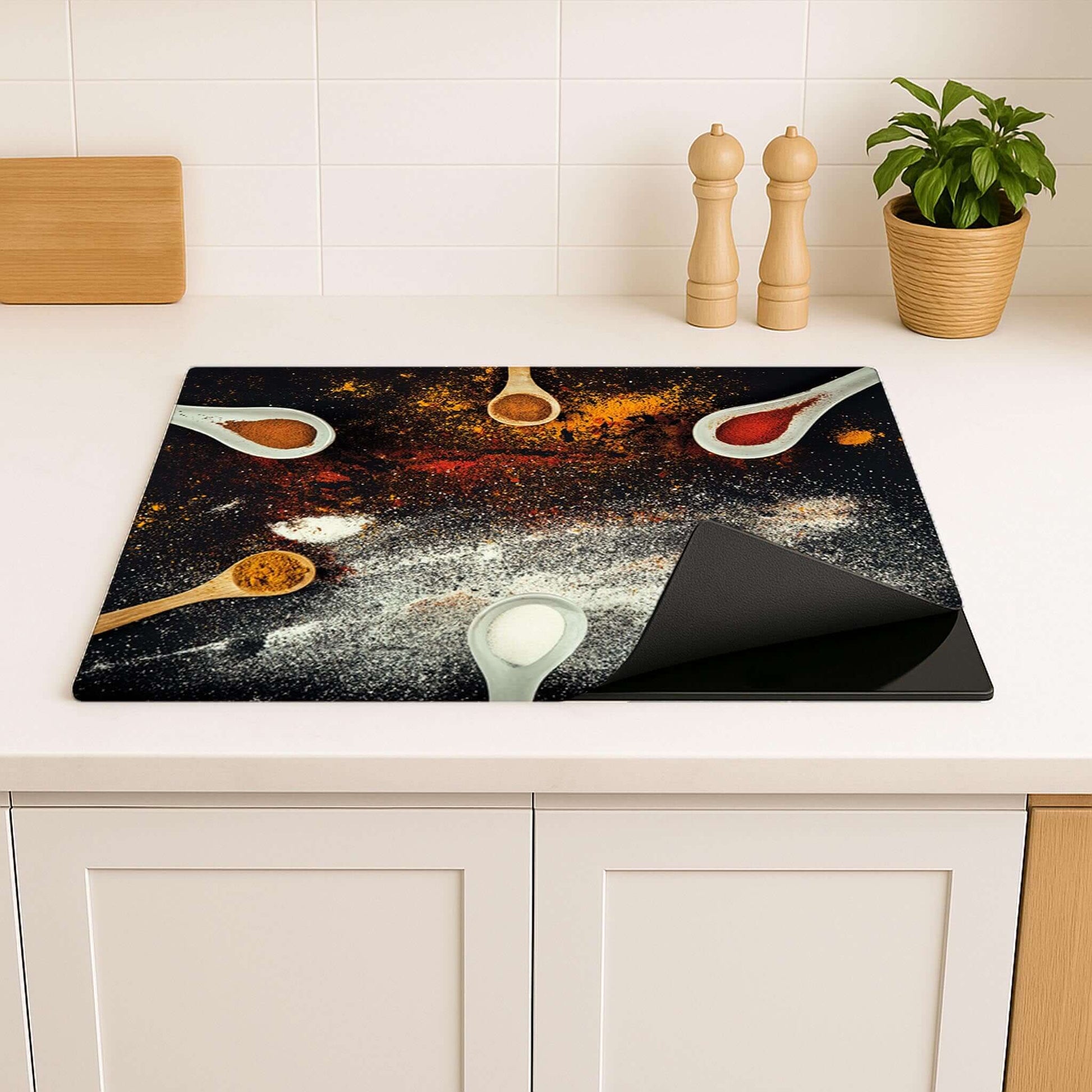 Close-up van Spice Fusion inductiebeschermer met specerijen en lepels op donker keukenblad